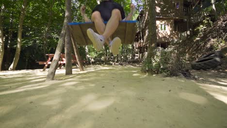 Young-man-swinging-on-swing,-slow-motion.